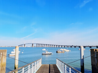Fototapeta premium Scenic view of a bridge over calm water and boats at the pier 