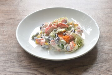 imitation crab stick with corn and garden pea couple cabbage vegetable topping shrimp egg salad dressing cream sauce on plate
