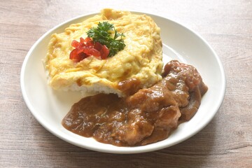 fried creamy egg omelet topping plain rice dressing potato and carrot in Japanese curry on plate 