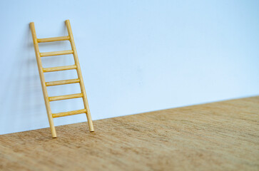A single wooden ladder standing tall against a white cover with customizable space for text or ideas.