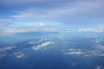 Fototapeta premium Beautiful white clouds drifting peacefully in the blue sky as seen from above or Layers of soft clouds stretching across the sky during a daytime flight.