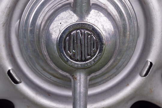 Geneva, Switzerland - october 04, 2025 : sign and logo on a metallic car wheel hubcap with embossed Lancia Artena logo in center.