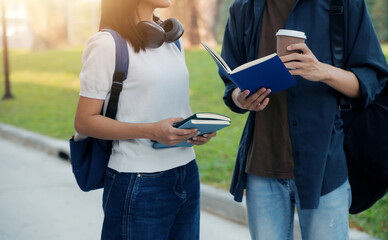 Happy students walking together on university campus, chatting and laughing outdoors after classes