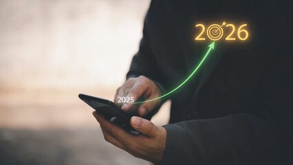 Businessman touching 2026 with arrow target icon, representing new year business goal, strategic...