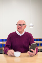 Portrait of a senior man using his mobile phone in a cafe