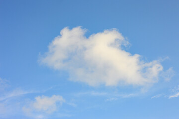 Bright blue sky with fluffy cumulus clouds on a clear day, showcasing a peaceful atmosphere and natural beauty