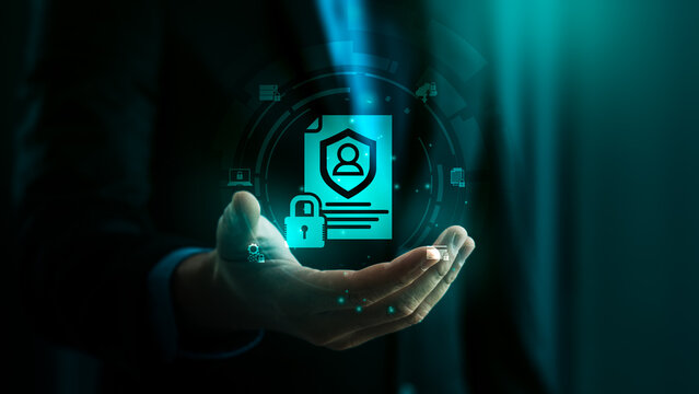 Data protection and cybersecurity concept with businessman holding hologram icon of secure personal information, digital privacy policy, and confidential identity management