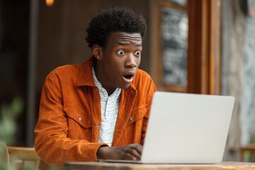 Portrait of excited college student reacting to good news on laptop, joyful facial expression symbolizing success, opportunity, and digital win.