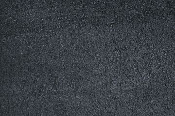 Fototapeta premium Close-up top view of fresh black asphalt road surface with visible texture and small stones, symbolizing infrastructure, progress, transport, and modern road construction.