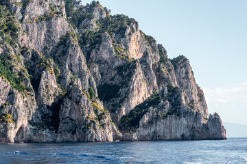 Capri, Italy - 04.29.2025: An interesting white rock formation with tree cover partially on the seashore of the island of Capri.