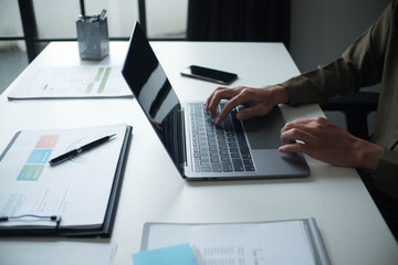 Businessman, entrepreneur, accountant working on financial report on desk using laptop.