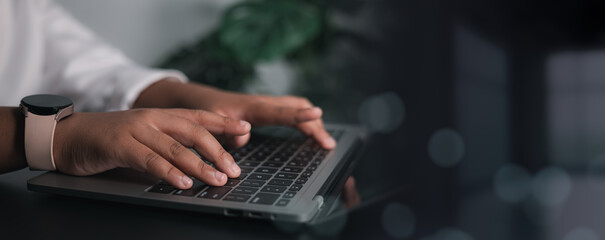 Person hands wearing a smart watch and typing quickly on a laptop keyboard. Concepts of remote work, professional communication, technology, online business, coding, and digital connection in a modern