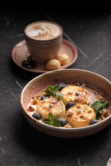 Delicious syrniki pancakes with blueberries, walnuts and mint leaves