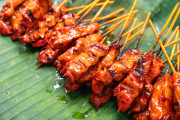 Thai style charcoal grilled pork (Moo Ping) placed on green banana leaves.
