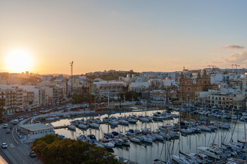 Obraz premium Sunset Over Marina with Yachts and Historic Church Skyline