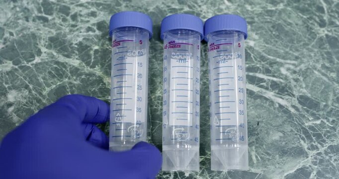 Three large test tubes on a green workbench in a laboratory. The scientist placed three empty test tubes on the table.