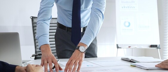Business team analyzing financial charts and graphs during strategy meeting in modern office, focusing on corporate planning, data analysis, and decision making