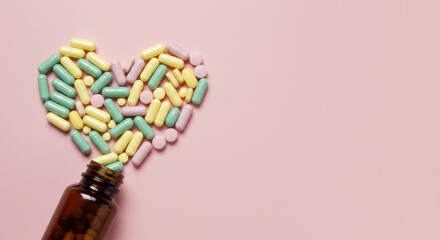 Colorful heart shaped pills pouring from bottle medicine health concept