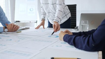 Business team analyzing financial charts during strategy meeting, professionals discussing data and performance metrics at workplace for decision making success