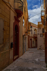 Narrow Historic Alley with Limestone Facades, Arched Doorway and Iron Balconies