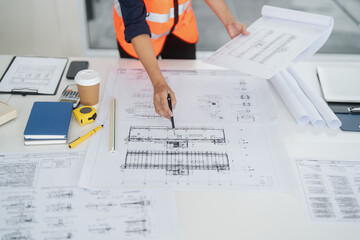 Engineer working with blueprints in indoor construction office