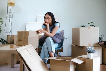 Woman anxious and fatigued packing boxes for moving to new residence