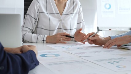 Business team meeting with financial documents and charts, discussing data analysis, planning strategies, and corporate success during collaborative teamwork session