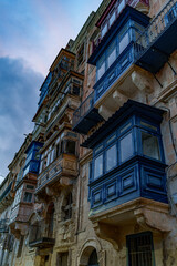 Upward View of Traditional Maltese Enclosed Balconies against Blue Evening Sky