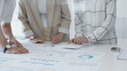 Professional team reviewing financial data, jointly analyzing charts and graphs in modern office, pointing at statistics during strategic planning. Business people concept