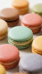 Fototapeta premium Colorful macarons arranged on a white surface, showcasing various pastel shades and smooth textures.