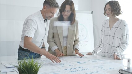 Professional team reviewing financial data, collaborating on working documents, demonstrating team achievements and positive dynamics in the workplace. Business people concept