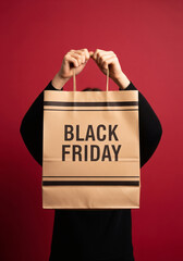 Person holding a black friday shopping bag promoting sales and discounts