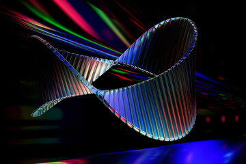 A vibrant, twisted loop structure is set against a black background. The loop reflects a spectrum of colors, creating a dynamic visual effect.AI generated.