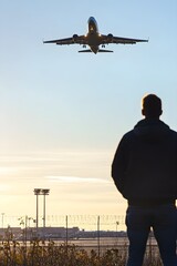 Man Watching Airplane Landing at Airport Sunset image