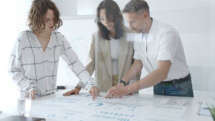 Professional team reviewing financial data, collaborating on working documents, demonstrating team achievements and positive dynamics in the workplace. Business people concept