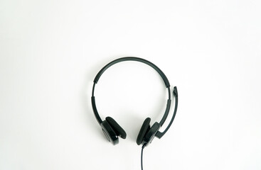 A pair of black on-ear headphones with a microphone boom, viewed from the top down on a white background. This image is perfect for concepts of a call center, customer service, communication, or music