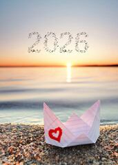 Beautiful shot of a paper boat at sunrise with a 2026 from birds in the sky for happy new travel year
