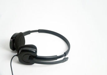 A pair of black on-ear headphones with a microphone boom, viewed from the top down on a white background. This image is perfect for concepts of a call center, customer service, communication, or music