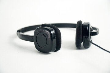 A pair of black on-ear headphones with a microphone boom, viewed from the top down on a white background. This image is perfect for concepts of a call center, customer service, communication, or music