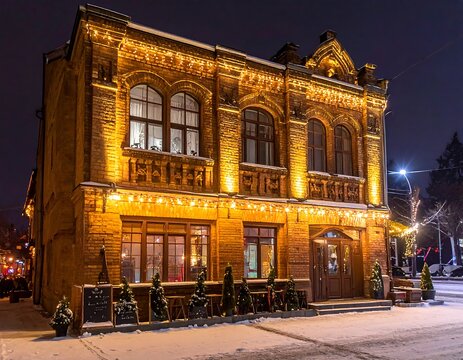 Historic brick building illuminated at night with festive string lights