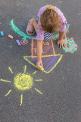 Fototapeta premium Children drawing with chalk on the asphalt. Selective focus.