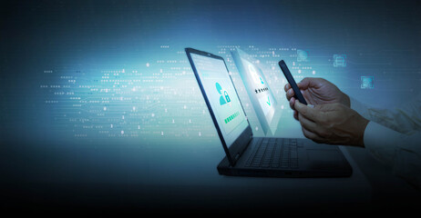 Hand of businessman using mobile phone and laptop computer with high tech background. Approval of a digital online purchase transaction or digital identity verification.