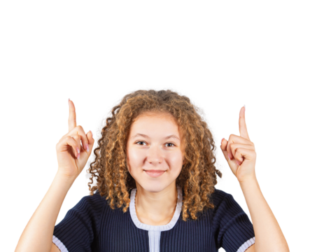 Contented teenage girl with curly hairstyle, pointing both forefingers up, looking positive to camera. Frizzy ginger woman adolescent isolated on transparent background
