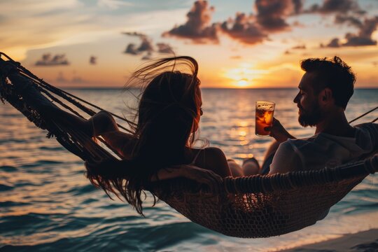 Romantic Sunset: A couple share an intimate moment of relaxation, sipping drinks while resting in a hammock, enjoying the warm hues of the sunset over the calm ocean.