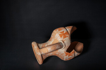 Broken ancient amphora on black background.	