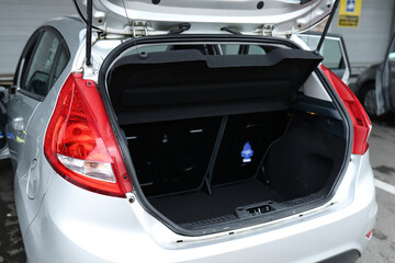 Open trunk of a gray car. Small trunk.