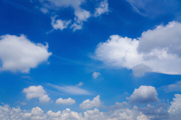 Clear blue sky with white fluffy clouds background. Bright sunny day with good weather and fresh air concept.