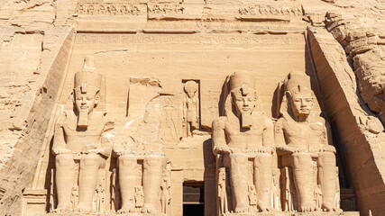 The facade of the famous temple of Abu Simbel, Egypt, with the statues of the pharaoh Ramsess the second. With several symbols and hieroglyphics.