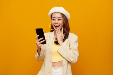 Excited Asian woman looking at smartphone with surprised expression modern digital lifestyle online...