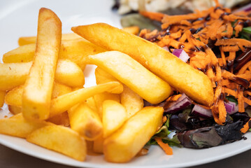 Enjoying a balanced meal: golden fries, crisp salad with shredded carrots, red onion, balsamic glaze, and creamy coleslaw. #food #lunch #delicious